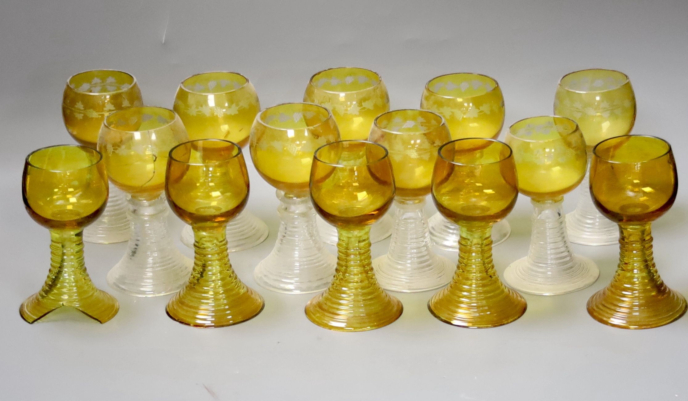 Fourteen German amber flashed roemers, nine wheel engraved with vines